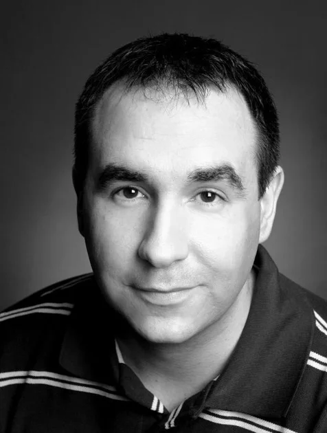 Darren Harris posing and wearing a striped shirt.