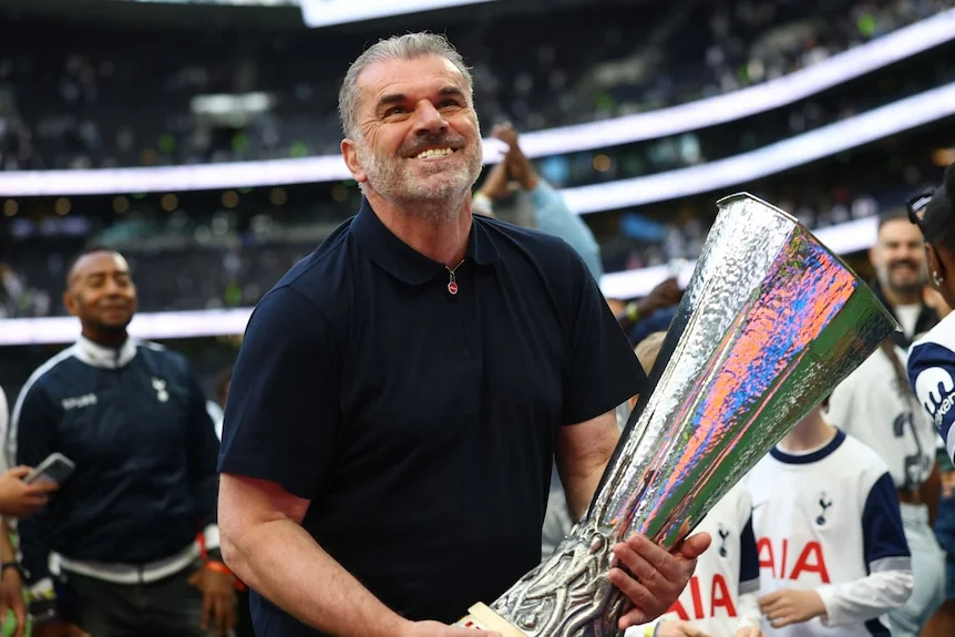 Tottenham Hotspur manager Ange Postecoglou with the Europa League trophy, massive smile at fans