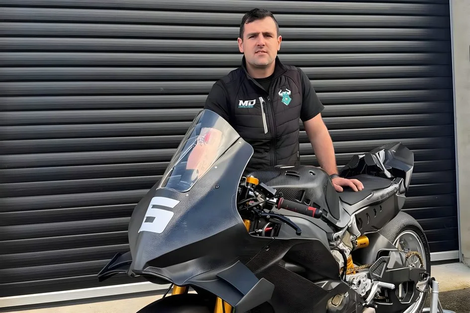 Michael Dunlop in MD Racing vest in front of his new Ducati Panigale V4 R for the 2026 Superbike class with visible carbon bodywork and race number 5 on the fairing in front of a grey workshop door