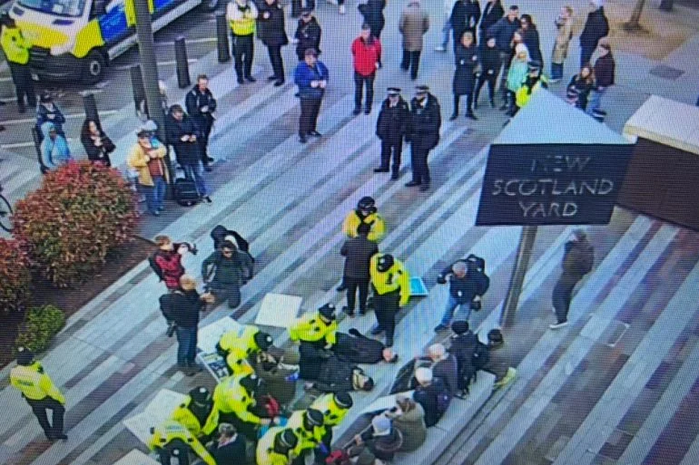 Metropolitan Police officers arrest Palestine Action supporters outside New Scotland Yard in London on Saturday