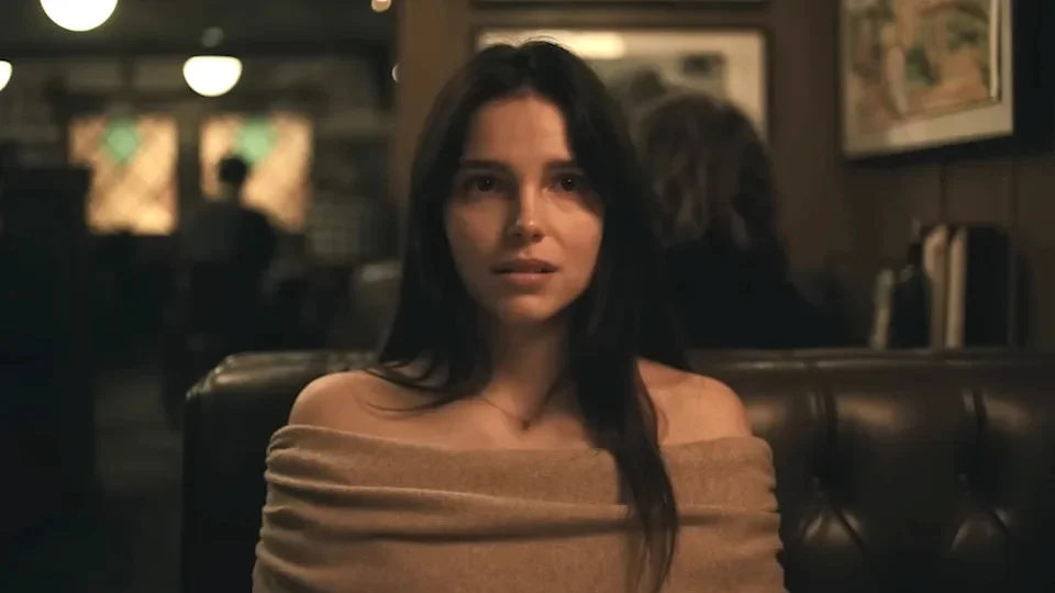 Inde Navarette sitting down at a restaurant booth as Nikki in Obsession