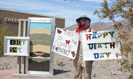 A protestor stands next to the heat display, warning visitors about the climate crisis.