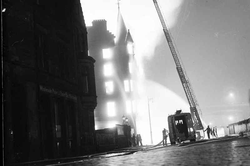 In 1955 two spectacular fires took places in Edinburgh within 24 hours of each other. First a fire at C W Carr warehouse and James Aitman show factory in Jeffrey Street.  Fire engine and extended ladder pictured at the scene.