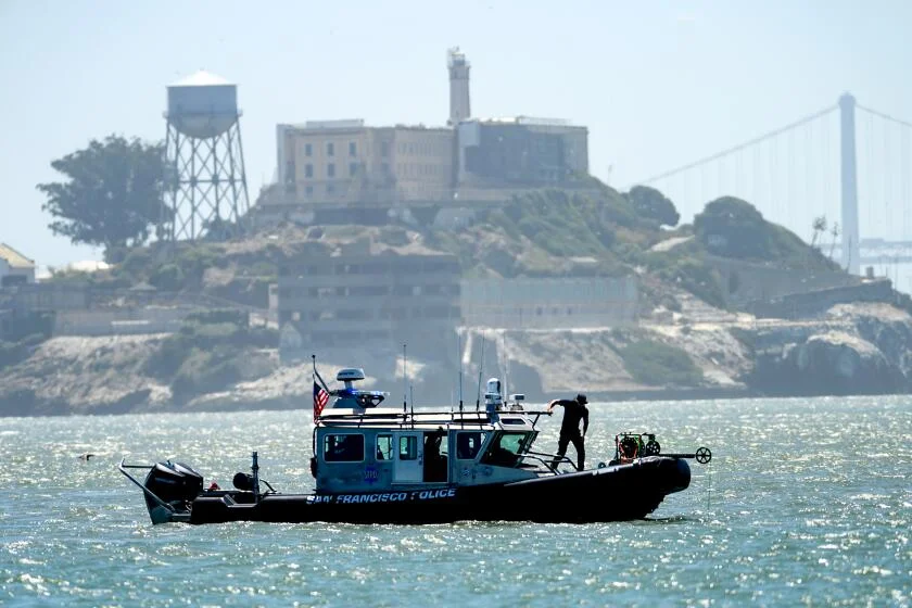 A police boat passes Alcatraz Island as search and rescue operations continue for victims of a Tuesday boat sinking on Wednesday, July 15, 2026, in San Francisco. (AP Photo/Noah Berger)