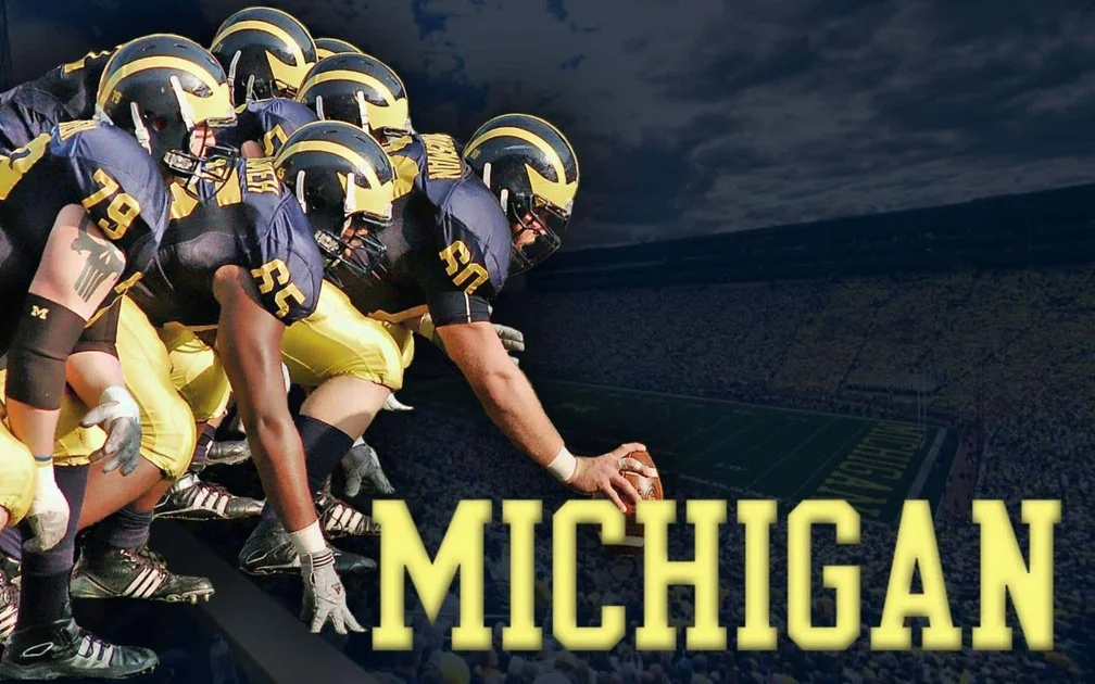 Michigan football team huddles before a game under dark clouds. — Michigan Wolverines Wallpaper
