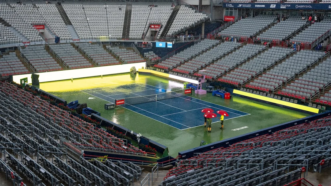People use umbrellas during a rain delay, on day two of the National Bank Open tennis tournament in Montreal on Monday.