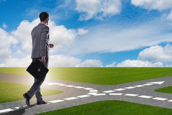 Young businessman at crossroads in uncertainty concept - Photo, Image
