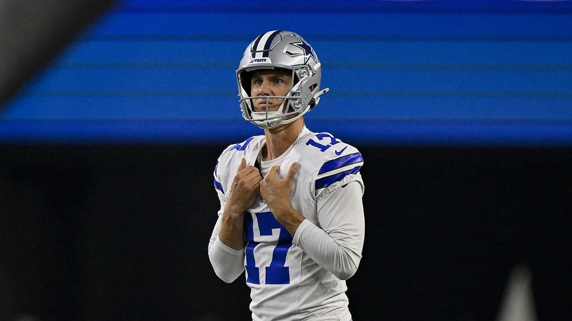 Dallas Cowboys kicker Brandon Aubrey grips his jersey at the collar as he lines up a field goal attempt.