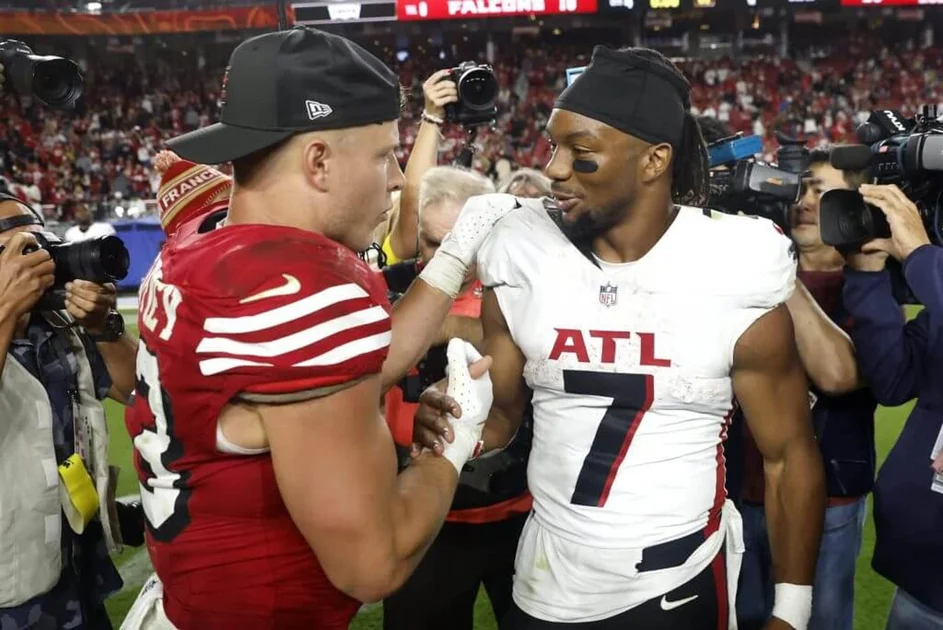 Christian McCaffrey of the San Francisco 49ers embraces Bijan Robinson of the Atlanta Falcons in the game at Levi's Stadium on October 19, 2025 in Santa Clara, California.